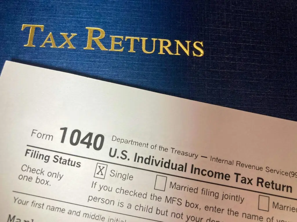 axpayer filing for IRS tax refund USA on a laptop, surrounded by W-2 forms and a calculator for easy refund claim.